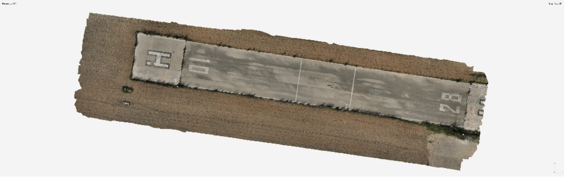 Aerial view of a rectangular concrete helipad with surrounding dirt, featuring helipad markings and faded lines