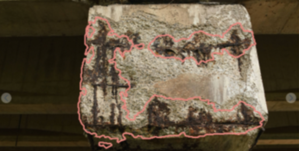 Close-up of a concrete structure with visible corrosion damage, highlighted by a pink outline, indicating areas affected by rust and deterioration
