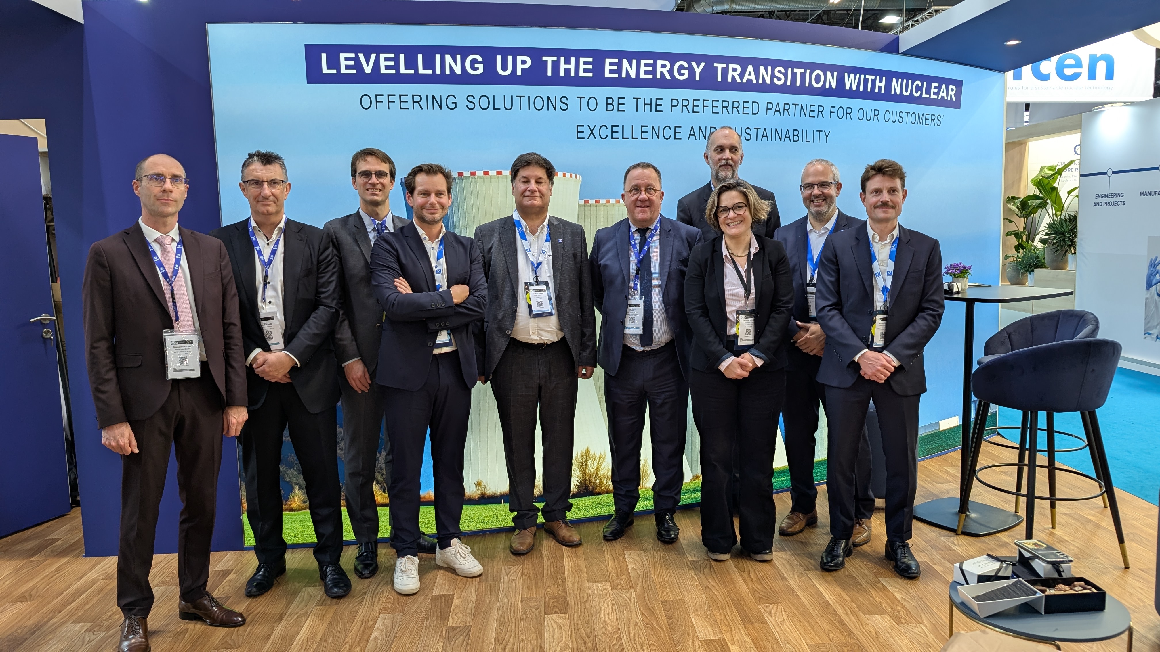 Group of Kiwa professionals at a trade show booth promoting energy transition with nuclear solutions, emphasizing excellence and sustainability