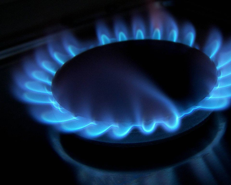 Blue flame on a lit gas stove burner, showing energy efficiency and heating power in a kitchen appliance