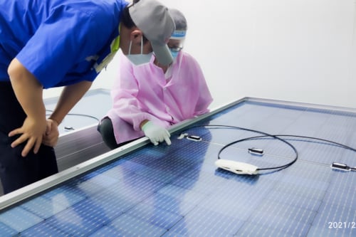 Kiwa PI Berlin auditors inspecting solar panel components in a cleanroom environment, highlighting quality control in solar energy production