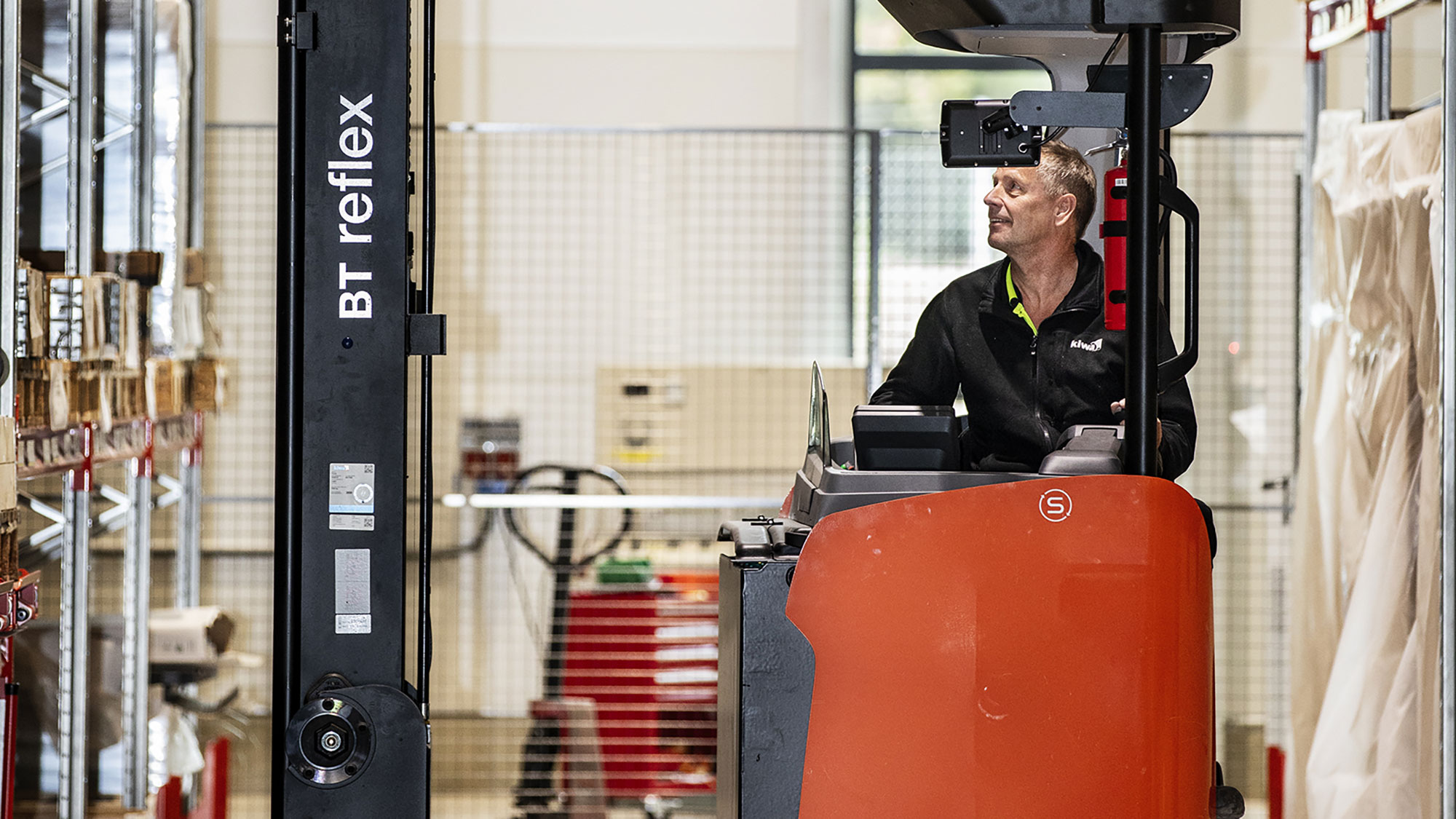 Besiktningsingenjör kontrollerar en truck på ett lager. 