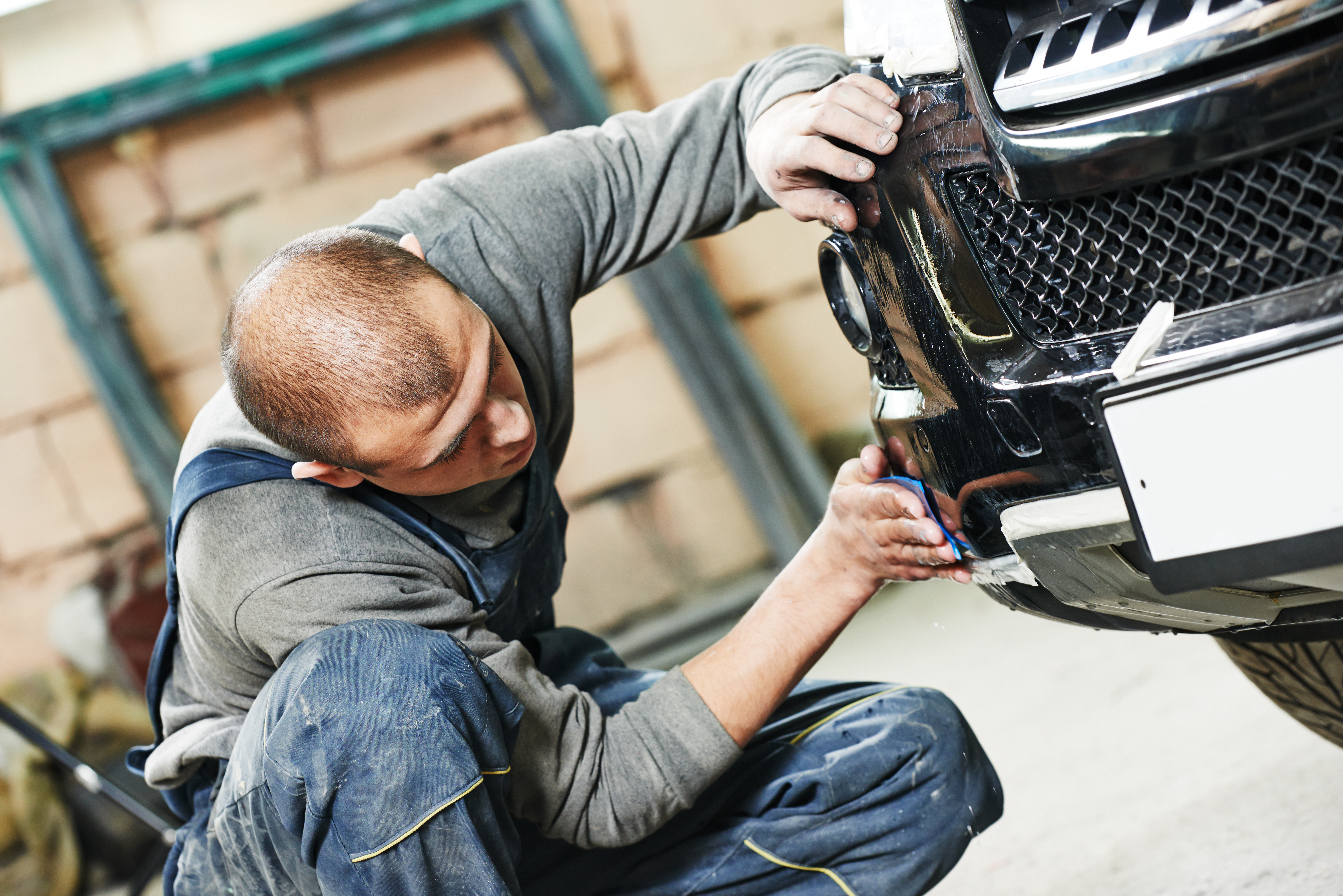  Mechanic working on the front of a car