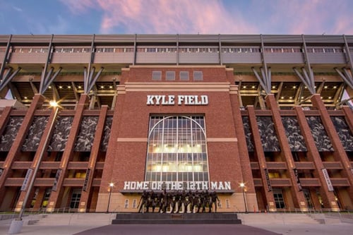 Kyle Field exterior at Texas A&M University, featuring red brick facade and iconic stadium signage at sunset