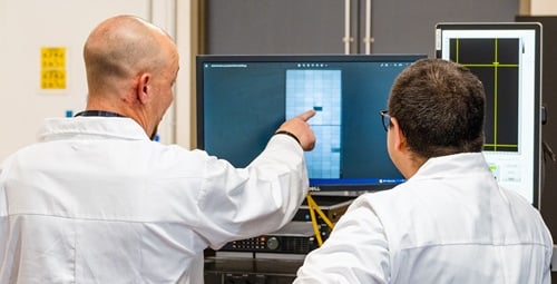 Two kiwa employees analyze PVEL's data on a laptop