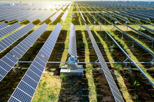 long grass field with countless solar pannels taking part in a batch testing session